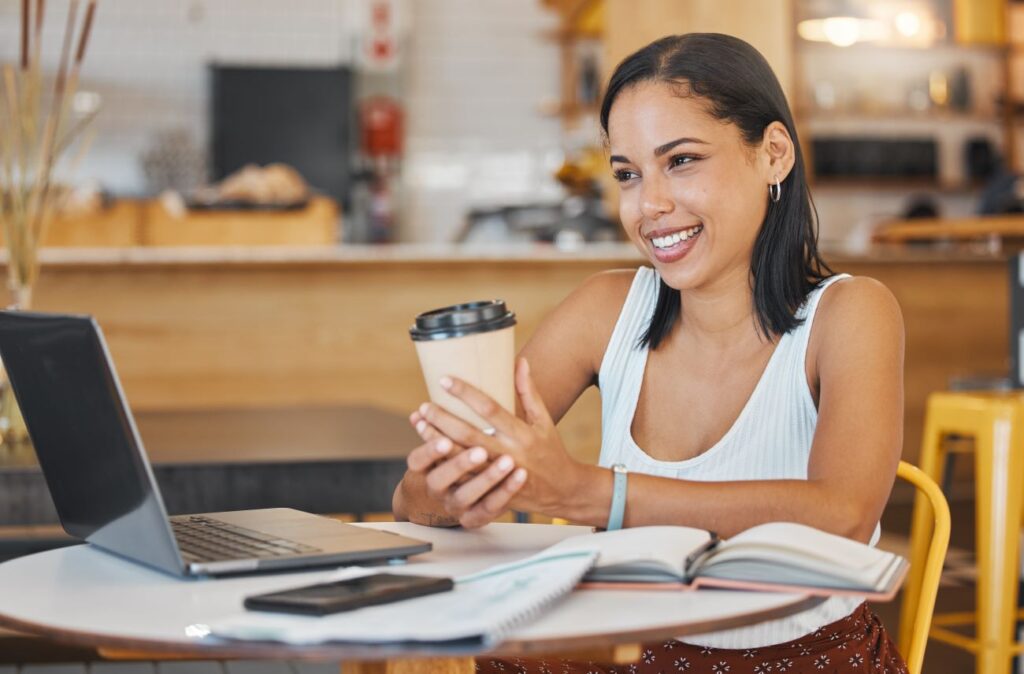 Mulher tomando café e estudando pelo notebook